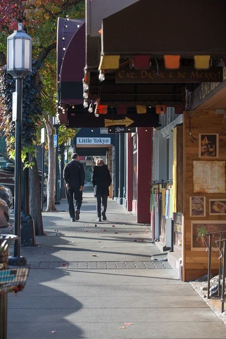 Two adults walking on a city sidewalk